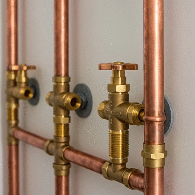 Modern copper pipes and plumbing fixtures in a residential setting