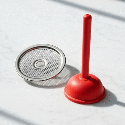Professional plumbing tools and a drain screen on a clean surface